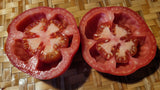A red ripe Pera Tipo Cosentino Tomato cut in half highlighting its open structure that makes it perfect for stuffing
